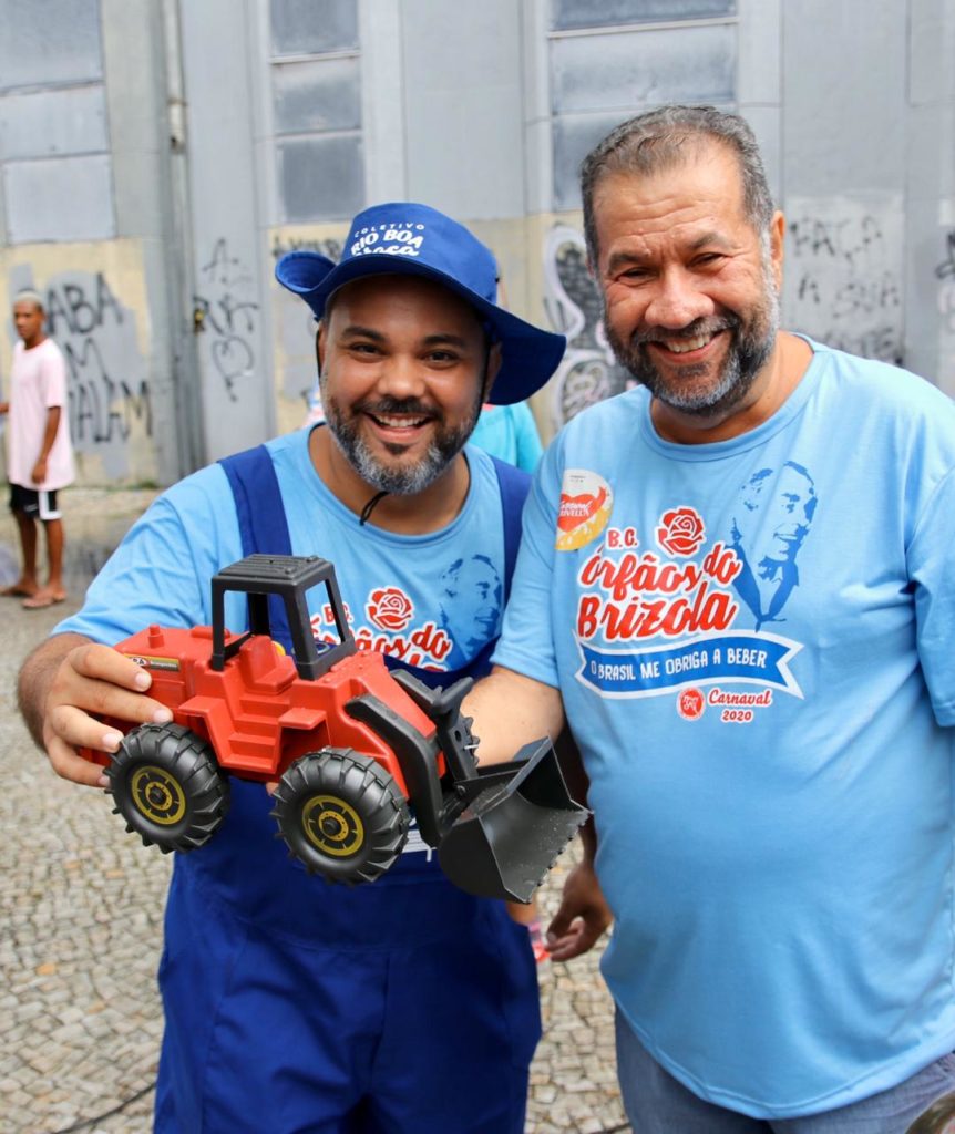 Everton Gomes e Carlos Lupi , com a miniatura da retroescavadeira