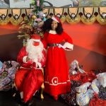 Simone Sampaio distribui presentes ao lado de Papai Noel de máscara na Dragões da Real Colunismo Social