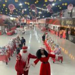 Simone Sampaio distribui presentes ao lado de Papai Noel de máscara na Dragões da Real Colunismo Social