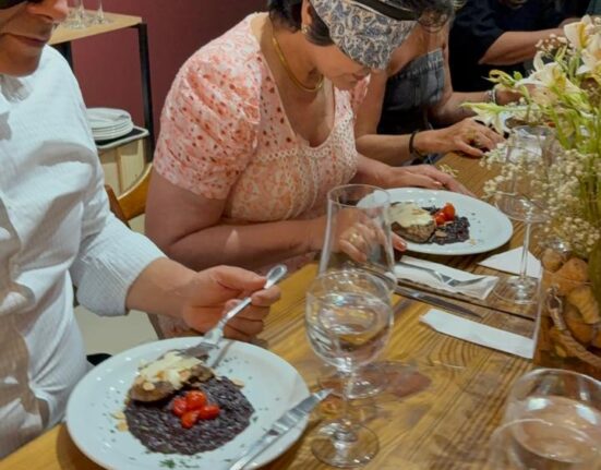Na noite de quinta-feira, 18, a Mescle elevou o conceito de confraternização com a realização da CONFRASHION na Adega Rivera. O evento foi um autêntico jantar às cegas, que desafiou os sentidos dos participantes a se guiarem unicamente pelo paladar e olfato, transformando a refeição em uma verdadeira experiência sensorial imersiva. A proposta foi além de um simples encontro, proporcionando uma jornada de descobertas onde a percepção dos sabores foi aguçada em um ambiente de total entrega. A experiência foi meticulosamente curada por Lorena Cantanhede, owner da Mescle, que trabalhou em parceria com o chef Andrés Garnica e a sommelier Danielly França. Juntos, eles guiaram os convidados em uma autêntica aula sobre harmonização. Em meio a pratos especialmente elaborados, a confraria teve a oportunidade de desvendar os segredos de rótulos do leste europeu, em uma demonstração de como a culinária e a enologia se complementam para criar uma experiência gastronômica completa e inesquecível. O evento reforçou a filosofia de que a verdadeira riqueza de um jantar reside no conhecimento e na percepção de cada detalhe. Beleza