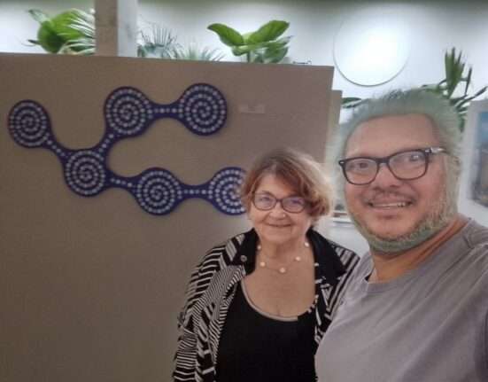 A Curadora da TBV Sra. Noys Rocha e o Curador Paulo Melo da Exposição Alma Negra Viva 2026 que se apresentará do dia 5 a 28 de fevereiro na Galeria da TBV (LBV) 915 Sul ao fundo obra do Artista Darlan Rosa. Rio de janeiro